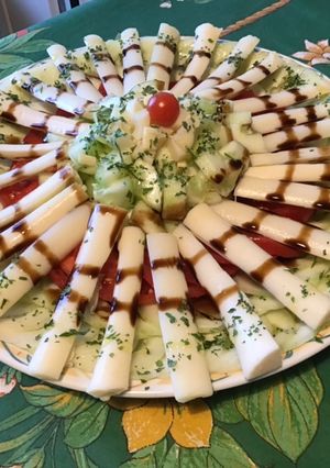 Une photo de Salade de concombres, tomates, coeurs de palmier au persil et crème de balsamique