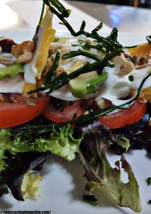 Una foto de Ensalada de queso fresco con tomate raf, aguacates, mango, salsa de yogurt y frutos secos