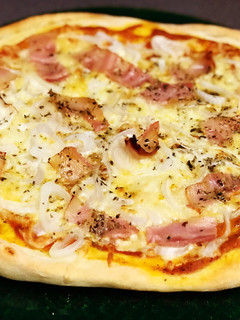 Una foto de Pizza de bacon y mucha cebolla con salsa casera de tomate, albahaca y orégano y masa artesanal