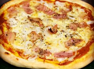 Foto principal de Pizza de bacon y mucha cebolla con salsa casera de tomate, albahaca y orégano y masa artesanal