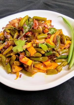A picture of French Beans and Potato Fry with Onions.