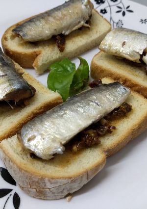 Una foto de Bruschettas con tomates secos y sardinas