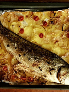 Una foto de Corvina al horno con lecho de patatas y cebolla