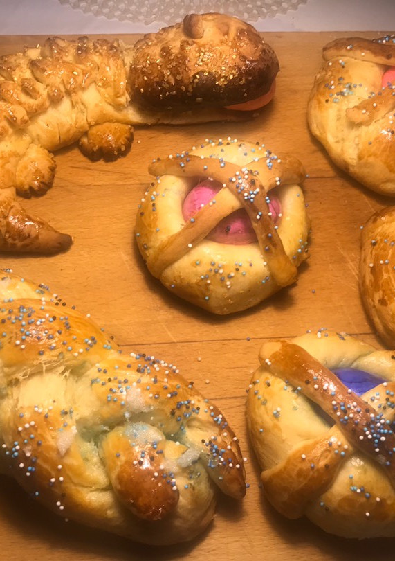 Una foto de Monas, el tsoureki y el dragoncito. Dulces de Pascua