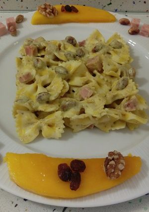 Una foto de Pasta farfalle de limón con crema de mango y pesto de frutos secos
