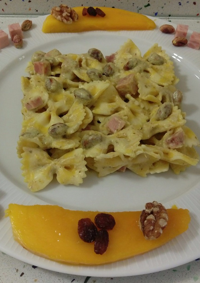 Una foto de Pasta farfalle de limón con crema de mango y pesto de frutos secos