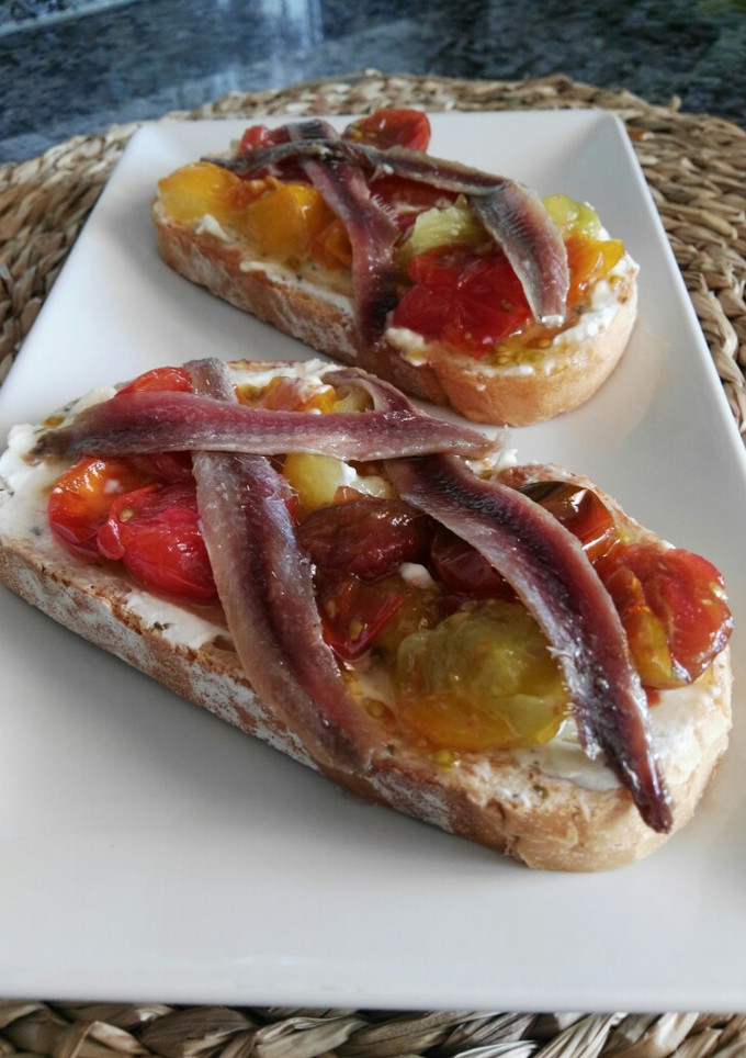 Una foto de Tostadas de queso, cherry caramelizados y anchoa