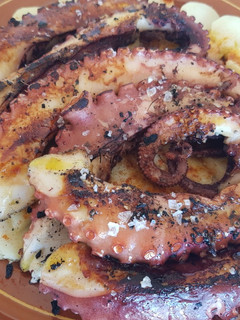 Una foto de Patas de pulpo a la brasa con lecho de patatas y pimentón