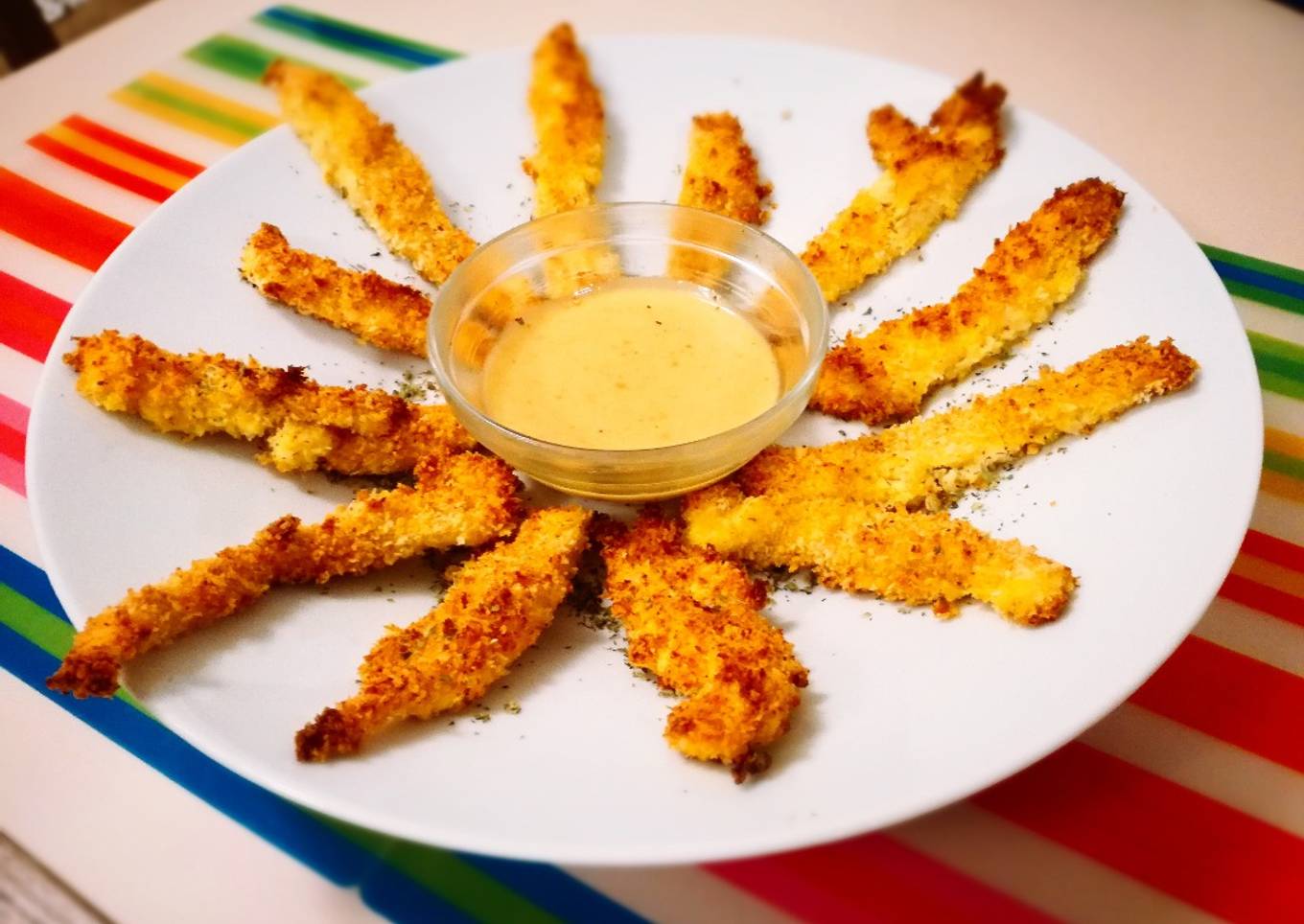 Delicias de pollo crujiente con rebozado de panko y parmesano, acompañadas de salsa miel y mostaza