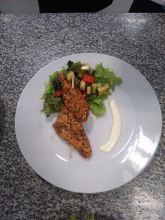 Una foto de Brochetes de pollo y ensalada fresca