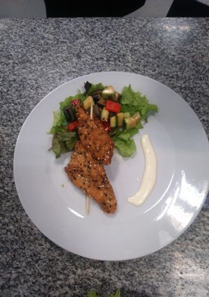 Una foto de Brochetes de pollo y ensalada fresca