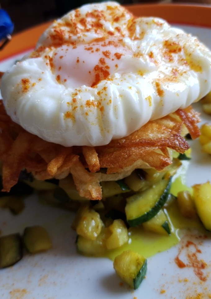Una foto de Timbal de verduras con patatas paja y huevo poche