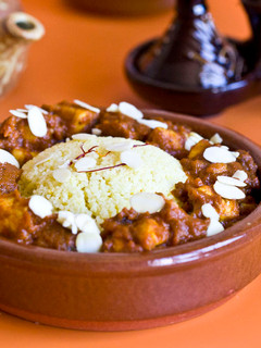 Una foto de Cous cous con dados de pollo, tomate, pasas, miel, almendras y especias