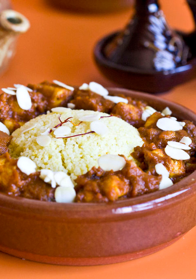 Una foto de Cous cous con dados de pollo, tomate, pasas, miel, almendras y especias