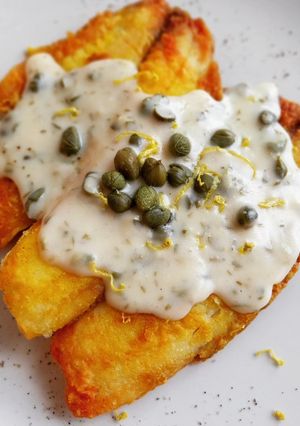 Una foto de Tilapia rebozada en cúrcuma con salsa de alcaparras