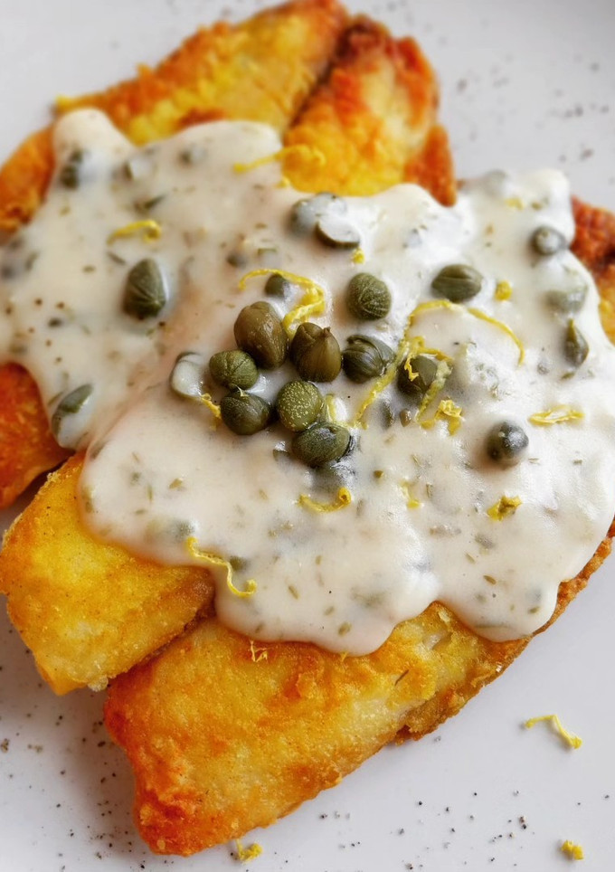 Una foto de Tilapia rebozada en cúrcuma con salsa de alcaparras