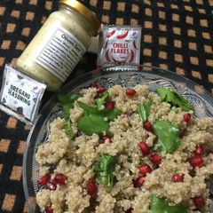 A picture of Quinoa, spinach and pomegranate salad with italian dressing.