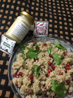 A picture of Quinoa, spinach and pomegranate salad with italian dressing.