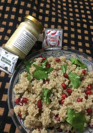 A picture of Quinoa, spinach and pomegranate salad with italian dressing.