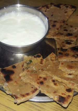 A picture of Onion paratha with curd.