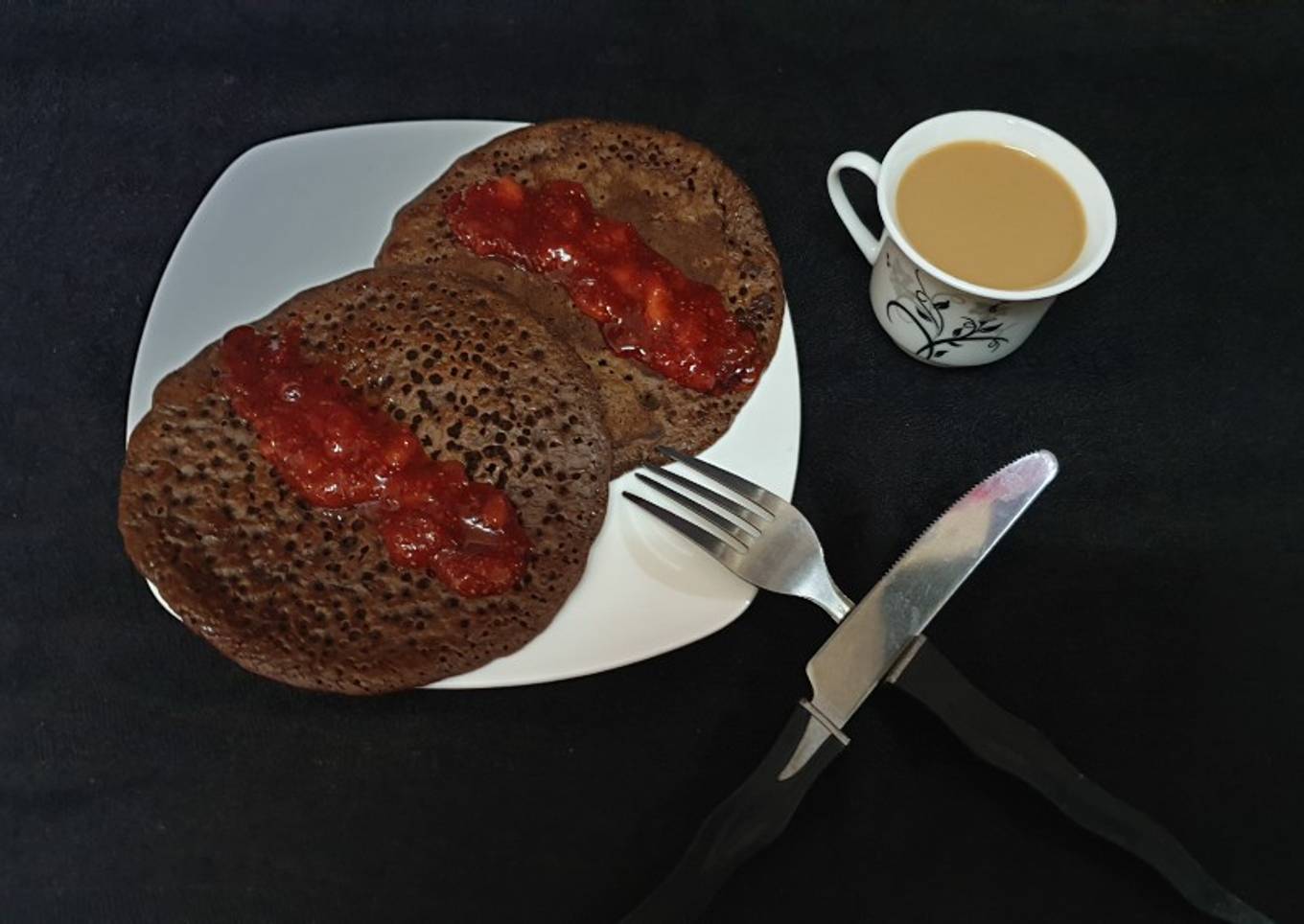 Chocolate pancakes with strawberry sauce