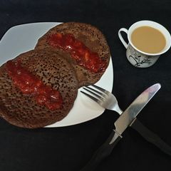 A picture of Chocolate pancake with strawberry sauce.