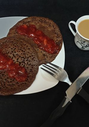 A picture of Chocolate pancake with strawberry sauce.