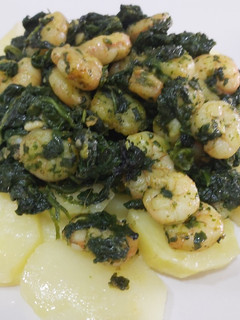 Una foto de Base de patatas con espinacas y gambas al ajillo