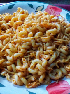 A picture of Jollof Maçaroni and Spaghetti with Fried Fish.