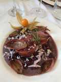 Cotechino su insalatina di fagioli neri e cocco e scalogni caramellati