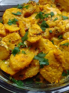Una foto de Papas al horno con ajo, perejil y queso parmesano