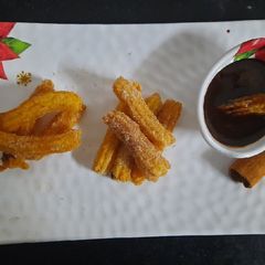 A picture of Churros with chocolate dip.