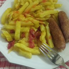 A picture of French fries with sausage.