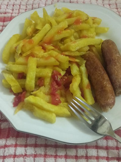 A picture of French fries with sausage.
