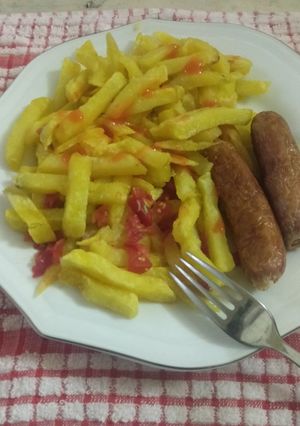 A picture of French fries with sausage.