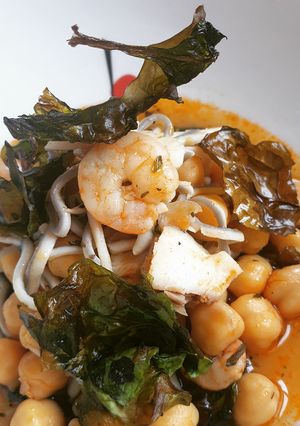 Una foto de Garbanzos de gulas, lubina y gambas con espinacas chips