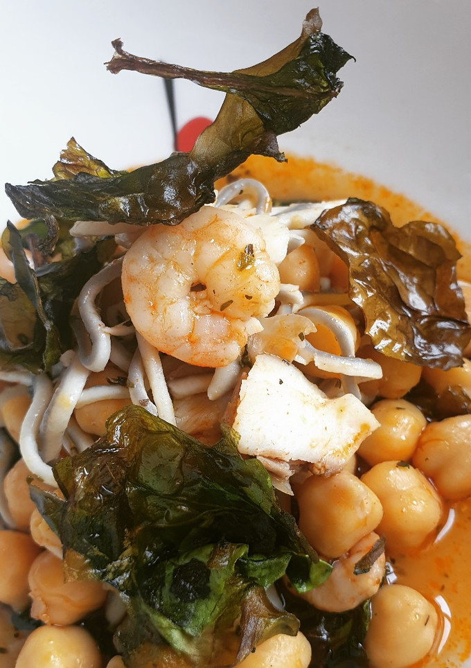 Una foto de Garbanzos de gulas, lubina y gambas con espinacas chips