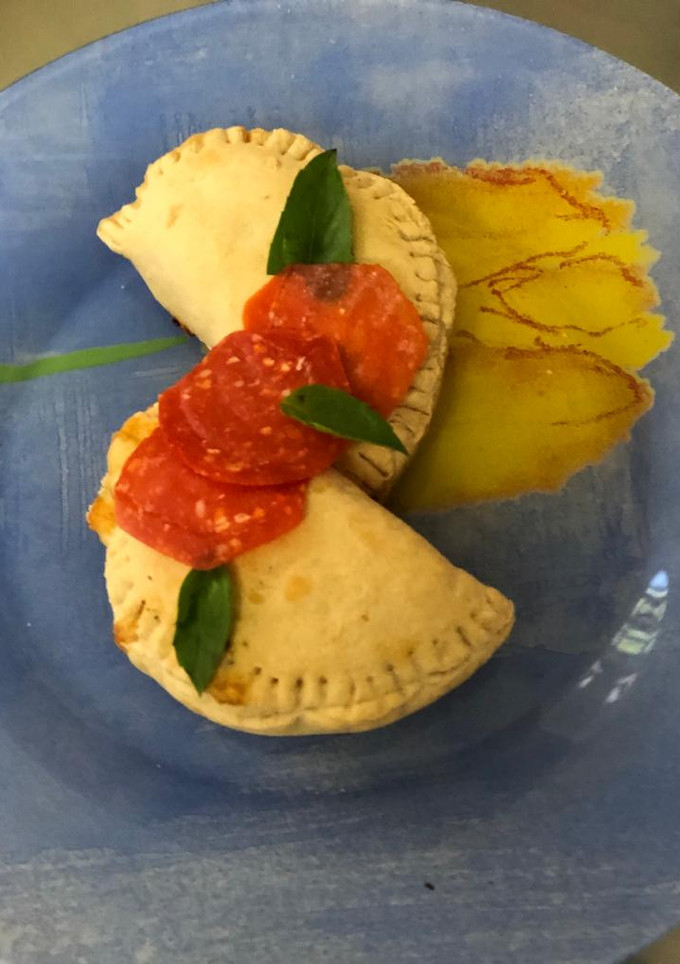 Una foto de Calzone ripieno di pepperoni e fromaggio al forno/ Pizza rellena
