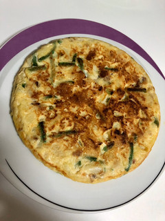 Una foto de Tortilla de patata con ajetes tiernos y gambas