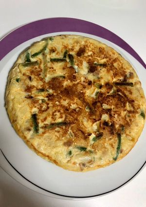 Una foto de Tortilla de patata con ajetes tiernos y gambas
