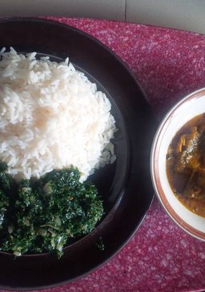 A picture of Rice with ofe akwu and vegetable.