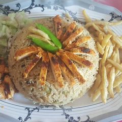 A picture of Peas pulao with chicken steak strips.