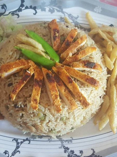 A picture of Peas pulao with chicken steak strips.