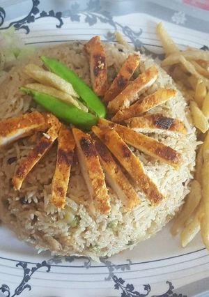 A picture of Peas pulao with chicken steak strips.