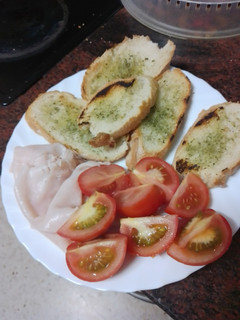 Una foto de Picoteo: Pan de ajo a la plancha con pechuga de pavo y tomate