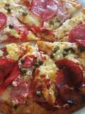 Pizza amb cuixot salat, dolç, salami i alcaparras amb vinagre