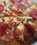 Pizza amb cuixot salat, dolç, salami i alcaparras amb vinagre