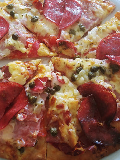 Una foto de Pizza amb cuixot salat, dolç, salami i alcaparras amb vinagre