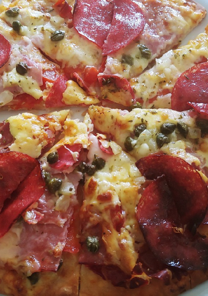 Una foto de Pizza amb cuixot salat, dolç, salami i alcaparras amb vinagre