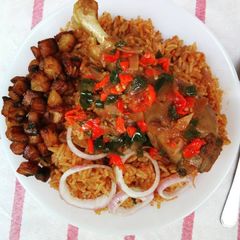 Jollof rice and fried chicken sauce garnished with plantain A picture of Jollof rice and fried chicken sauce garnished with plantain.